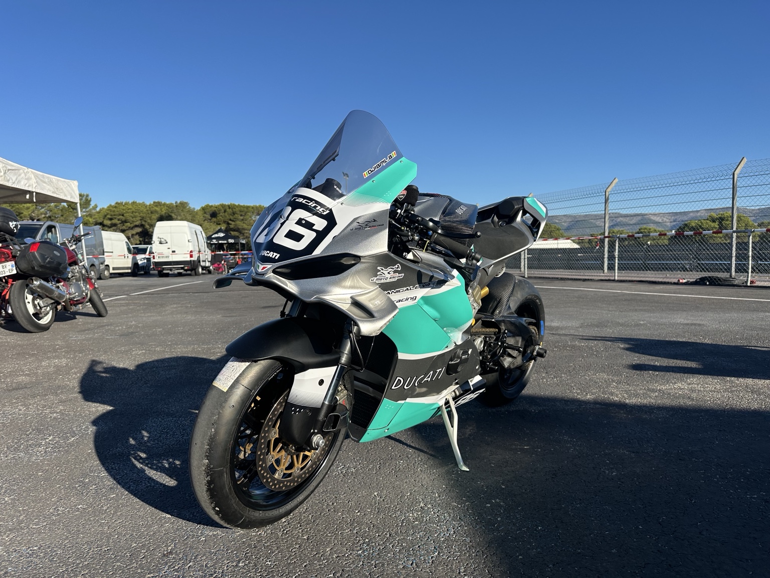 Panigale V4 n°86 en configuration piste, poly Ducati et décoration ASD grise et turquoise, vue de trois quarts avant